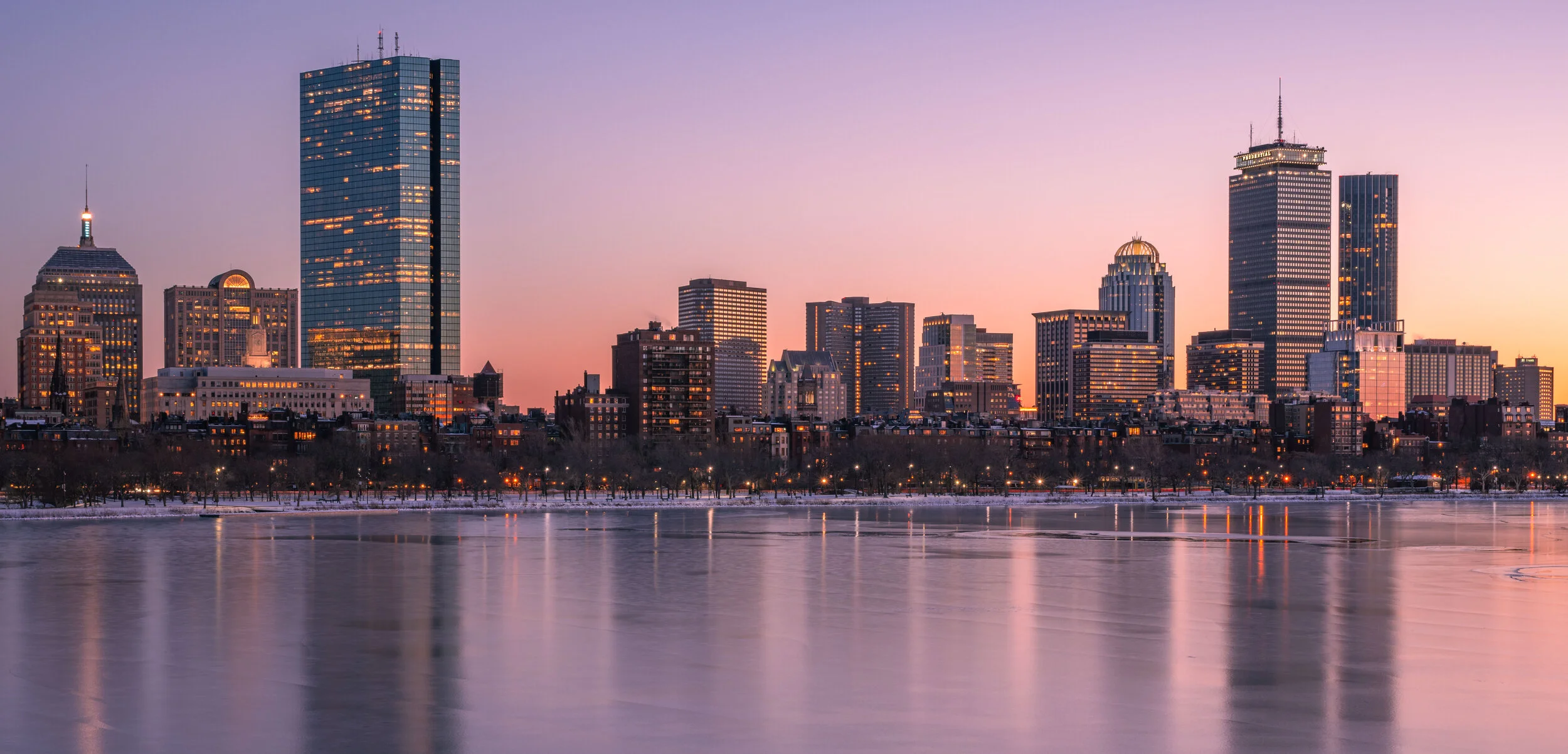 Boston city skyline at dusk featuring modern skyscrapers and waterfront