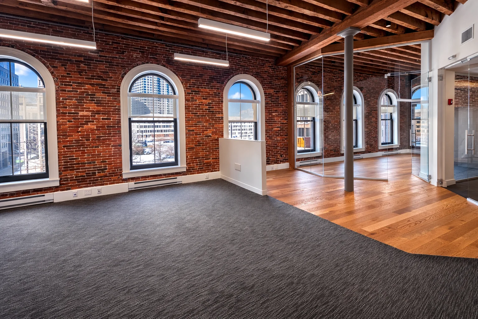 Industrial-style office interior with exposed brick, wood beams, and natural light